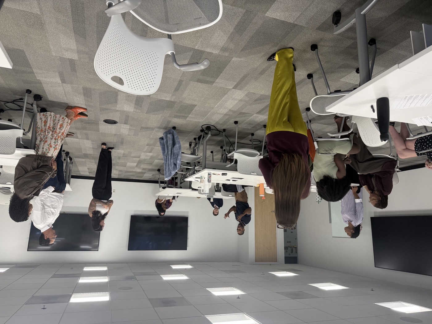 Workshop participants standing in a circle during a facilitated improv exercise, corporate conference room, Atlanta